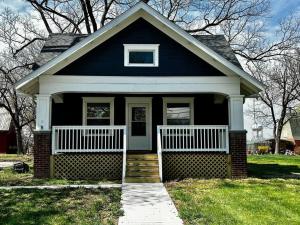 a blue house with a white porch and stairs at Mrs. Hughes Cottage - 2 bedroom House w/ parking in Hamilton