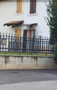 a black fence in front of a white house at Casa Adige in Verona