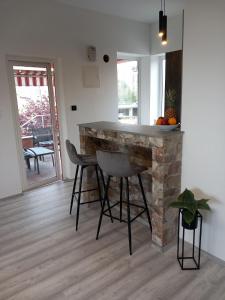 Una cocina con encimera y taburetes en una habitación. en Apartman ANI, en Rijeka