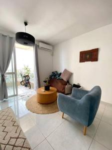 ein Wohnzimmer mit einem blauen Stuhl und einem Sofa in der Unterkunft Cozy 2-bedrooms with balcony 20 in Bat Yam