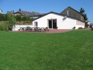 a white building with picnic tables in a yard at Groepsverblijf Snowview Lodge in Medendorf