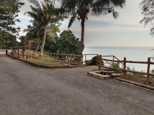 a fence on the side of a road next to the ocean at Colobeentoi Three Bedroom Sea View in Port Dickson