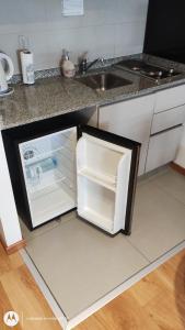 an open refrigerator in a kitchen next to a sink at Julia´s apartment in Buenos Aires
