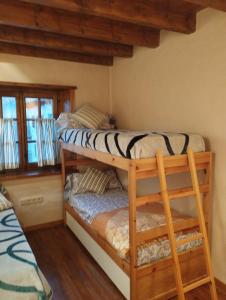 two bunk beds in a room with wooden ceilings at Esquí, Aigüestortes y Boí-Taüll a tus pies en EbreHogar in Pla de l'Ermita