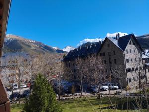 a large building with a mountain in the background at Esquí, Aigüestortes y Boí-Taüll a tus pies en EbreHogar in Pla de l'Ermita