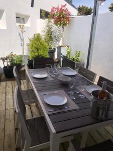 a wooden table with plates and wine glasses on a patio at la sardine dorée in Sangatte