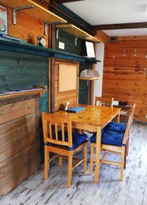 ein Esszimmer mit einem Holztisch und Stühlen in der Unterkunft Muskátli Vendégház in Szeged