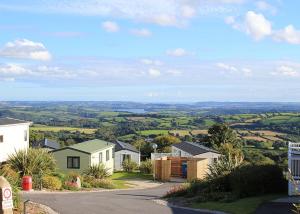 a house on a hill with a view of the countryside at Tamar View Holiday Park in Gunnislake