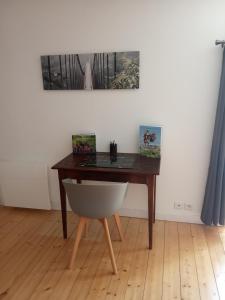 escritorio con silla blanca y mesa de madera en Le Cosy, en Hiersac