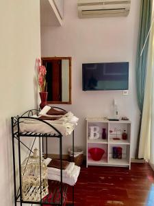 Pokój z telewizorem i półką z ręcznikami w obiekcie Bellini w Cagliari