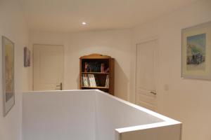 Una escalera blanca en una habitación con estantería en Le Cosy, en Hiersac