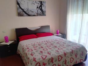- une chambre avec un grand lit et des oreillers rouges dans l'établissement Sul Lungo lago da Tatiana B&B, à Dagnente
