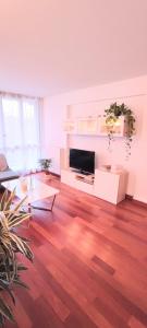 a living room with wood floors and a flat screen tv at Bel appartement entre Disney Land et Paris in Chelles