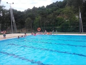 a group of people in a large swimming pool at Piso turístico Baralla in Baralla