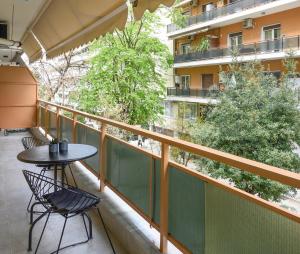 een balkon met een tafel en stoelen en een gebouw bij Blu & Marrone Suites-free parking in Thessaloniki