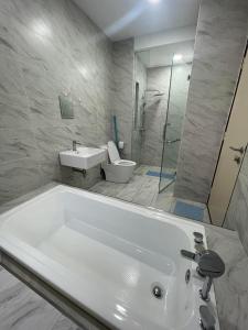 a bathroom with a tub and a sink and a toilet at Melaka Imperio Residence with Wifi and PoolSeaview in Malacca
