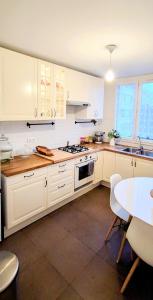 a kitchen with white cabinets and a table in it at Bel appartement entre Disney Land et Paris in Chelles