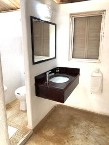 a bathroom with a sink and a mirror and a toilet at Villa Polinesia Chamela in Pérula +25 photos