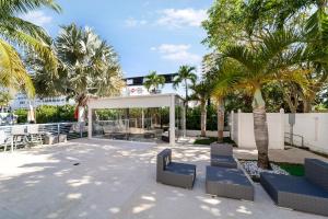 een patio met blauwe stoelen en palmbomen bij Deco Boutique Hotel in Fort Lauderdale