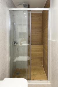y baño con ducha de cristal y lavabo. en Blu & Marrone Suites-free parking, en Tesalónica