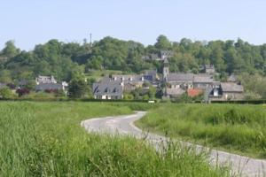 un camino sinuoso a través de un campo con un pueblo en Maisonnette au pied du Mont Dol, en Mont-Dol