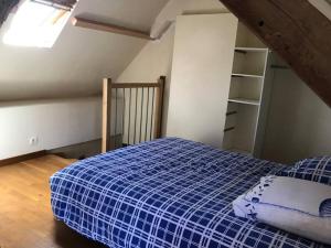 1 dormitorio con 1 cama azul en el ático en Maisonnette au pied du Mont Dol, en Mont-Dol