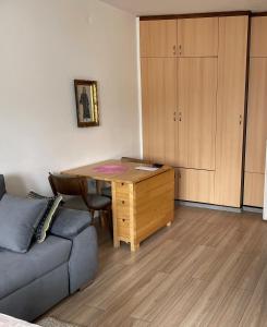 ein Wohnzimmer mit einem Sofa und einem Holzschreibtisch in der Unterkunft STAN 54m2 in Priboj