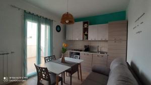 Una sala de estar con un sofá y una mesa y una cocina. en La casa di Steno, en Lecce