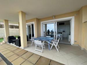 patio con mesa y sillas en el balcón en Le Verande di Isola Rossa, en Isola Rossa