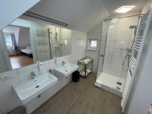 uma casa de banho branca com 2 lavatórios e um chuveiro em Ferienhaus Auerhahn em Vöcklabruck