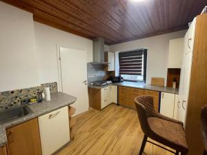 a kitchen with white cabinets and a wooden floor at Ferienhaus Auerhahn in Vöcklabruck