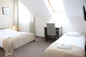 Pokój hotelowy z 2 łóżkami i biurkiem w obiekcie Villa AgaTomDom w Gdańsku