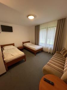 ein Hotelzimmer mit 2 Betten und einem Fenster in der Unterkunft Leśniczówka "Przyłęsko" in Rybakowo