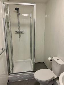 a bathroom with a shower with a toilet and a sink at The Derby Hotel in Barrow in Furness