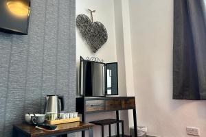 un espejo en una pared junto a un mostrador con una mesa en The Derby Hotel, en Barrow-in-Furness