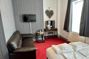 uma sala de estar com um sofá e uma televisão em The Derby Hotel em Barrow in Furness