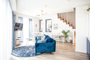 a living room with a blue couch and a staircase at Space Apartments Old Town - River View in Szczecin