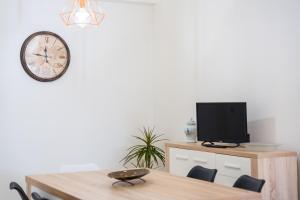 a dining room with a table and a clock on the wall at FLH Santa Cruz Triplex with Terrace in Santa Cruz
