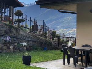 a patio with a table and chairs and a fence at Villa Sole in Aosta