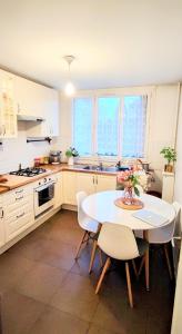 a kitchen with a table and chairs in a kitchen at Bel appartement entre Disney Land et Paris in Chelles