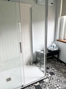 a shower with a glass door in a bathroom at Un air de campagne à Baudival in Le Cateau