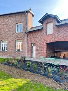 ein Backsteinhaus mit Garten davor in der Unterkunft Un air de campagne à Baudival in Le Cateau