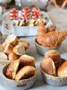 four baskets of breads and croissants on a table at Un air de campagne à Baudival in Le Cateau