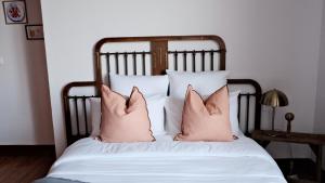 - un lit avec 2 oreillers roses dans l'établissement Un air de campagne à Baudival, à Le Cateau