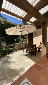 een patio met een parasol en een tafel en stoelen bij Cabañas La Cascada in Zacatlán