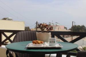 a table with a plate of pastries and a cup of coffee at Rodi Apartments 1 in Kamari