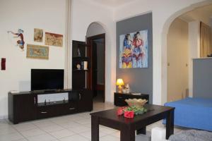 a living room with a tv and a coffee table at Rodi Apartments 1 in Kamari
