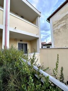 a building with a fence and bushes in front of it at Appartamento al centro di Pula in Pula