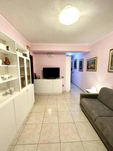 a living room with a couch and a tv at Appartamento al centro di Pula in Pula