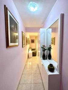 a hallway with two vases on a shelf with a mirror at Appartamento al centro di Pula in Pula